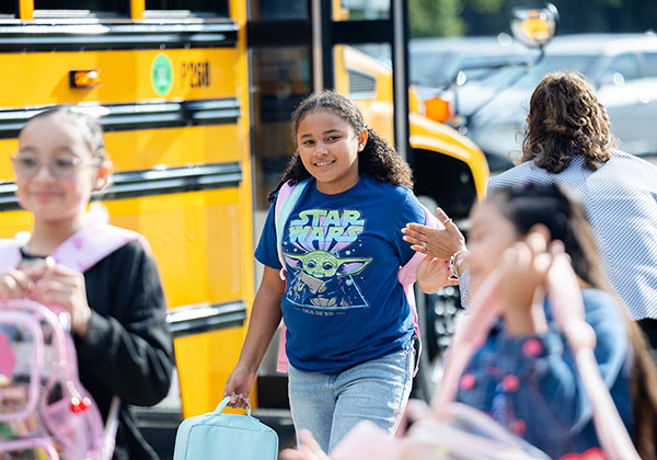 Children exiting school bus on first day of school.