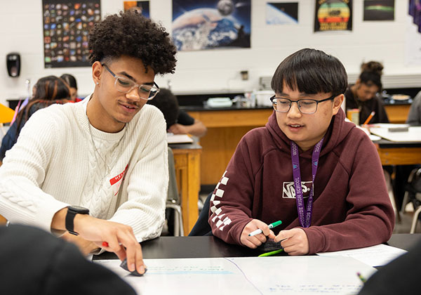 Two students working together at a table.